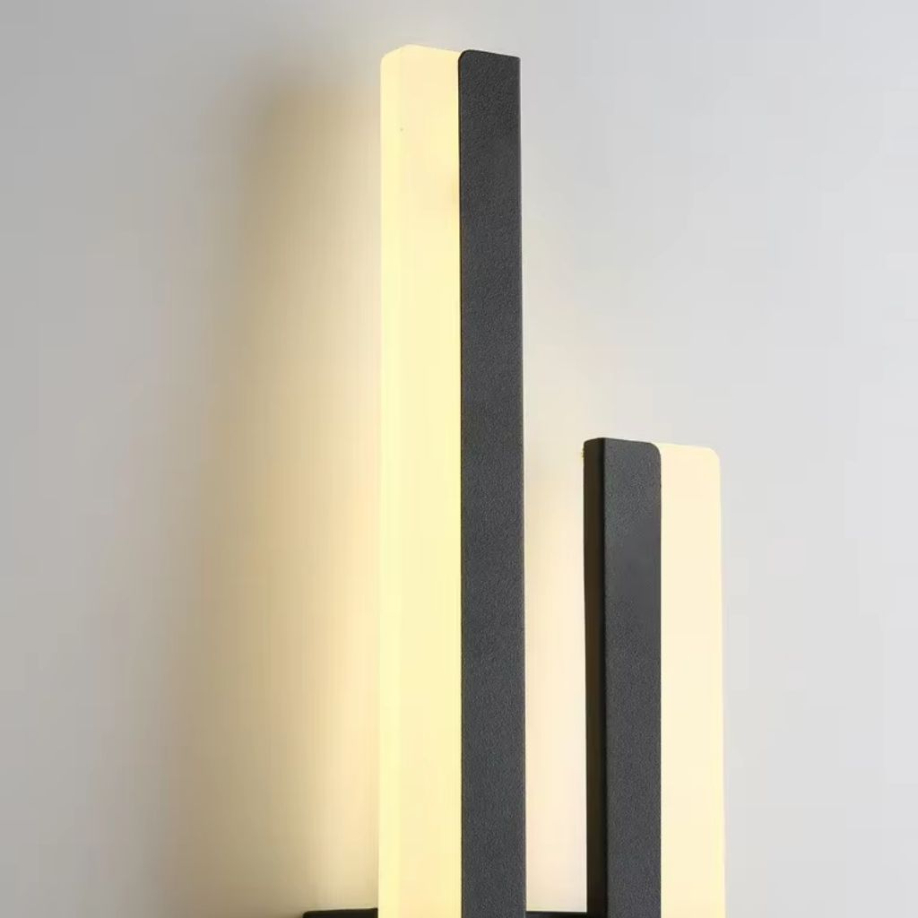 Two modern wall lights with black and white design on a gray background